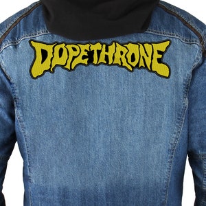 May include: A denim jacket with a yellow embroidered patch that says "DOPETHRONE" on the back.