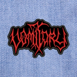 May include: Black and red embroidered patch with the word "VOMITORY" in a stylised font.