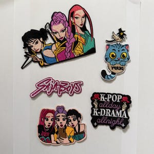 Puede incluir: Un conjunto de parches bordados con diseños de dibujos animados coloridos. Los parches incluyen imágenes de figuras femeninas estilizadas, un gato azul con un pájaro y texto que dice "Simpboys" y "K-POP allday K-DRAMA allnight".