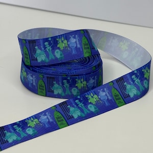 Könnte beinhalten: Eine Rolle blaues Ripsband mit einem sich wiederholenden Muster aus grünen und türkisfarbenen Geisterfiguren und Grabsteinen. Das Band ist abgerollt und zeigt die weiße Unterseite. Ideal zum Basteln und um Projekten eine gruselige Note zu verleihen.