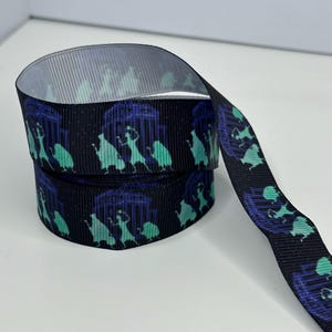 Könnte beinhalten: Schwarzes Ripsband mit einem sich wiederholenden Muster aus teal- und lilafarbenen Figuren und architektonischen Elementen. Geeignet für Bastelarbeiten, Geschenkverpackungen oder zum Hinzufügen einer dekorativen Note.