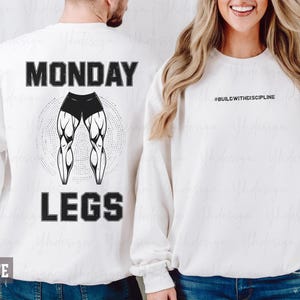 Puede incluir: Sudadera blanca con el texto "MONDAY LEGS" y un gráfico de piernas musculosas. La sudadera también tiene el texto "#BUILDWITHDISCIPLINE" en la parte delantera. La palabra "WHITE" está en la parte inferior de la sudadera.