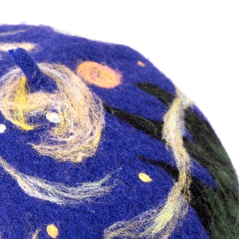 Pu&ograve; includere: Un berretto di lana blu con un motivo a spirale di giallo, bianco e nero, che ricorda un cielo stellato.