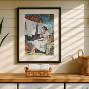 Vintage laundry print in black frame above counter with wicker baskets and plants, sunlit wall.