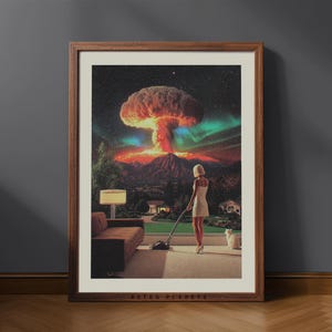 Könnte beinhalten: Gerahmter Kunstdruck mit einer surrealen Szene: Eine Frau saugt einen Teppich, während im Hintergrund eine Atompilzwolke aufsteigt. Das Kunstwerk hat eine Retro-Ästhetik, mit einem braunen Holzrahmen und dem Text "RETRO PLANETS" unten.