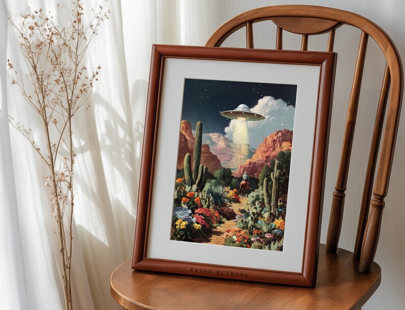 Retro cowboy UFO poster framed on a wooden chair near a sunlit curtain, rustic farmhouse western vibe.