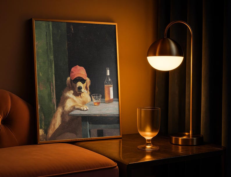 May include: A framed art print depicts a golden retriever wearing sunglasses and a red cap, smoking a cigarette, and sitting at a table with a drink and a bottle. A gold-toned lamp and a glass are on a dark surface.