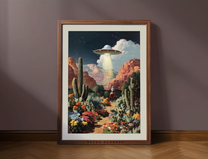Retro UFO cowboy wall art framed in wood leaning against a brown wall, rustic Western mood with warm desert tones.