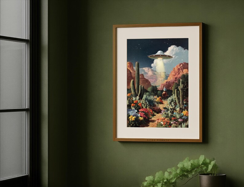 Colorful retro alien Western print framed on a deep green wall by a window, rustic farmhouse desert style.