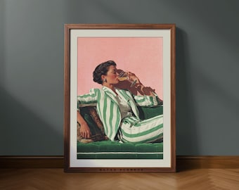 May include: Framed art print featuring a woman in a green and white striped suit, drinking from a wine glass. The artwork is set against a pink background, with a green velvet sofa. The frame is a dark brown color. The text "RETRO PLANETS" is at the bottom.