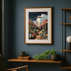 UFO desert cowboy poster framed on a navy wall above a modern wooden desk with plants, eclectic and quirky vibe.