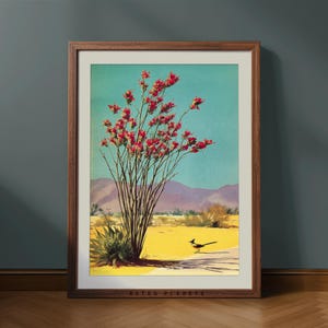 May include: A framed art print featuring a desert landscape with a vibrant red-flowered bush, a roadrunner, and mountains under a turquoise sky. The print is in a wooden frame, with the text "RETRO PLANETS" at the bottom.