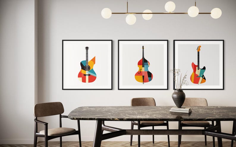 Op de afbeelding: Drie ingelijste prints van abstracte geometrische ontwerpen van muziekinstrumenten. De prints tonen een gitaar, een bas en een elektrische gitaar. De prints hangen aan een witte muur boven een houten tafel met stoelen.