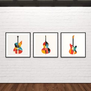 Op de afbeelding: Drie ingelijste prints van geometrisch ontworpen muziekinstrumenten. De instrumenten zijn een gitaar, een contrabas en een elektrische gitaar. De instrumenten zijn allemaal in tinten rood, oranje, geel, blauw en zwart.