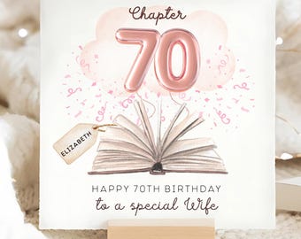 May include: A birthday card with a watercolor illustration. The card features a pink balloon number 70, the word "Chapter", and an open book. Text reads "Happy 70th Birthday to a special Wife" and a tag with the name "Elizabeth".