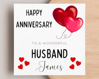 Puede incluir: Una tarjeta blanca con el texto "Happy Anniversary to a wonderful Husband James" y globos rojos en forma de corazón. También hay pequeños corazones rojos esparcidos alrededor del texto.