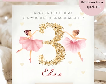 May include: A birthday card with the text "HAPPY 3RD BIRTHDAY TO A WONDERFUL GRANDDAUGHTER" and the name "Eden". The number "3" is in gold glitter, flanked by illustrations of ballerinas in pink tutus. The card has a wooden base.