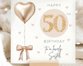 May include: A white card with a pink and gold design. The card says "Happy 50th Birthday to a lovely Sister" with a gold heart balloon and pink hearts.