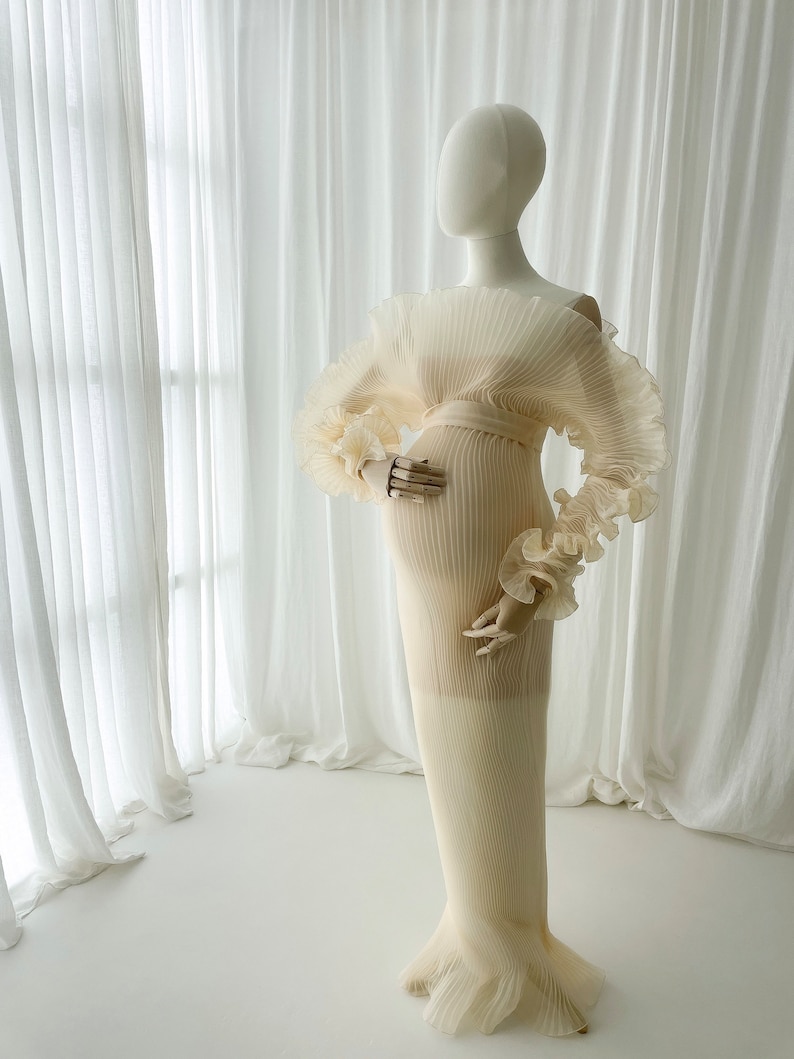Full-length side profile of the Celessia gown on a mannequin, emphasizing the flow and length of the skirt, designed to catch the wind for dramatic "flying dress" outdoor maternity portraits.