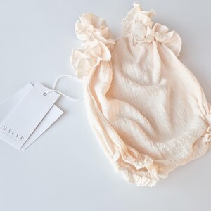 Versatile studio foundation piece. Vanilla off-white baby girl clothes in premium breathable cotton. Comfortable, high-stretch design for calm newborn outfit changes during memorable hospital announcement photography sessions.