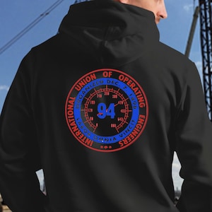 May include: A black hooded sweatshirt featuring a circular graphic on the back. The design includes the text International Union of Operating Engineers, Organized Dec. 7, 1896, and Labor Omnia Vincit, surrounding a gauge with the large blue number 94.