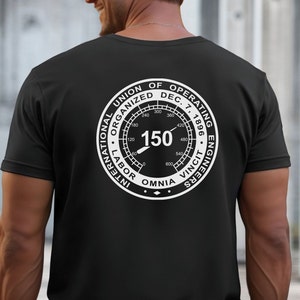 May include: Black t-shirt featuring a white graphic on the back. The graphic is a circular design with the text "INTERNATIONAL UNION OF OPERATING ENGINEERS DEC. 7, 1896" and the number "150". The words "OMNIA VINCIT" are also included.