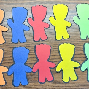 May include: Ten paper cutouts of a cartoon character in different colors: orange, blue, red, yellow, and green. The character has a round head, a wide smile, and raised arms.
