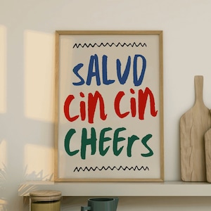 May include: A white ceramic mug with a black handle and the text "But First, Coffee" in a bold, black font. The mug is set against a blurred background, suggesting a cozy setting.