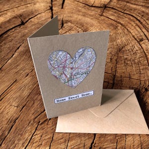 May include: A tan greeting card featuring a heart-shaped cutout filled with a colourful street map section showing the text CROYD. Below the heart, a white rectangular label displays the black printed text Home Sweet Home. A matching envelope.