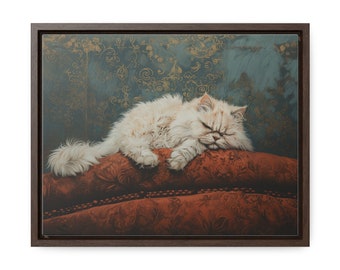 Puede incluir: Impresión en lienzo enmarcada que representa un gato blanco durmiendo. El gato descansa sobre un cojín rojo estampado, sobre un fondo verde azulado con detalles florales dorados. La obra de arte está encerrada en un marco marrón oscuro.