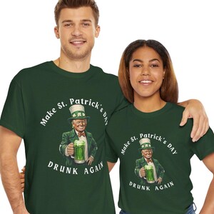 Könnte beinhalten: Zwei grüne T-Shirts mit einer weißen Grafik eines Mannes, der einen grünen Hut trägt und eine Bierkrüge hält. Der Text auf dem Shirt lautet "Make St. Patrick's Day Drunk Again".
