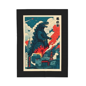 A black blanket featuring a Godzilla-themed design. The artwork depicts Godzilla in a city setting with red and blue hues, reminiscent of a vintage Japanese poster. The blanket is rectangular and placed on a bed.