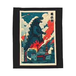 A black blanket featuring a Godzilla-themed design. The artwork depicts Godzilla in a city setting with red and blue hues, reminiscent of a vintage Japanese poster. The blanket is rectangular and placed on a bed.