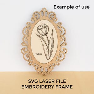 Puede incluir: Un marco de bordado de madera cortado con láser con un centro ovalado que presenta una ilustración de tulipán y la palabra "Tulipa". El marco tiene un diseño calado y ornamentado. El texto "SVG LASER FILE EMBROIDERY FRAME" está en la parte inferior.