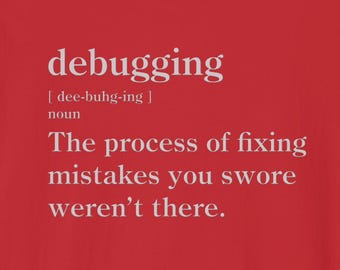 May include: A red t-shirt with the definition of "debugging" printed in white. The definition includes the pronunciation, the word "noun", and the phrase "The process of fixing mistakes you swore weren't there."