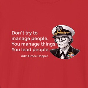 May include: Red t-shirt with a white quote that reads "Don't try to manage people. You manage things. You lead people. Adm Grace Hopper" and a black and white illustration of a woman in a navy uniform.