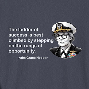 May include: A navy blue t-shirt with a quote by Adm Grace Hopper: "The ladder of success is best climbed by stepping on the rungs of opportunity." The quote is printed in white text and is accompanied by a black and white illustration of Adm Grace Hopper in her Navy uniform.
