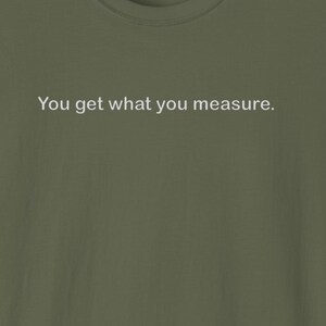 May include: A green t-shirt with the text "You get what you measure." printed in white on the front.