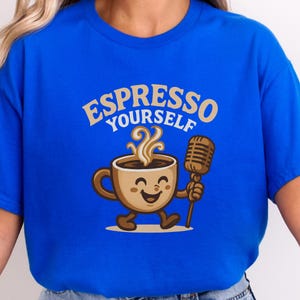 Peut inclure: T-shirt bleu roi avec un dessin animé d'une tasse à café tenant un microphone vintage. Le texte "ESPRESSO YOURSELF" est arqué au-dessus de la tasse à café. La tasse à café a un visage souriant et de la vapeur qui s'en échappe.