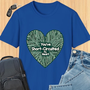 Könnte beinhalten: Ein königsblaues T-Shirt mit einem grünen Herzdesign aus einer Leiterplatte. Der Text "You've Short-Circuited My Heart" ist auf dem Herzen aufgedruckt.