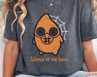 May include: Dark gray t-shirt featuring a cartoon yam character with button eyes, a hashtag mouth, and a spiderweb. The text "Silence of the Yams" is printed below the graphic. A fun, Halloween-themed design.
