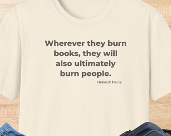 May include: Cream-colored t-shirt with the quote "Wherever they burn books, they will also ultimately burn people." by Heinrich Heine in gray text. The word "NATURAL" is printed at the bottom.