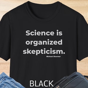 May include: Black t-shirt featuring the quote "Science is organised scepticism" in white, attributed to Michael Shermer. The word "BLACK" is printed at the bottom of the shirt.