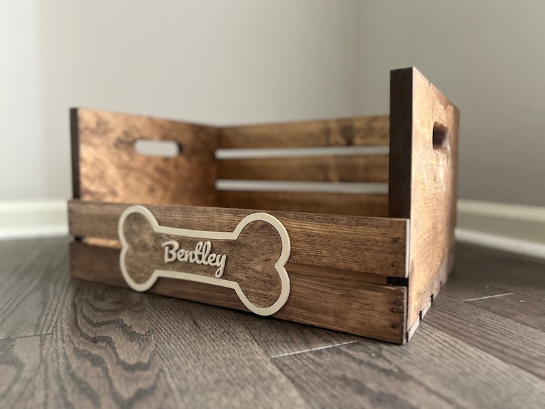 May include: A wooden dog bed with a bone-shaped plaque that says "Bentley".