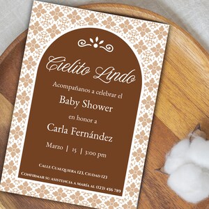 Könnte beinhalten: Eine braune und weiße Babyparty-Einladung mit einem dekorativen Rand. Die Einladung lautet "Cielito Lindo" und enthält den Text "Baby Shower" zu Ehren von Carla Fernandez. Datum und Uhrzeit der Party sind der 15. März um 15:00 Uhr. Die Einladung enthält auch eine Kontaktnummer zur RSVP.