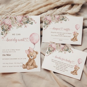 Op de afbeelding: Een set babyborrel uitnodigingen en kaarten. De hoofduitnodiging toont de tekst "We can bearly wait" met een teddybeer die een roze ballon vasthoudt. Extra kaarten bevatten "diaper raffle" en "books for baby" met bijpassende teddybeer illustraties.