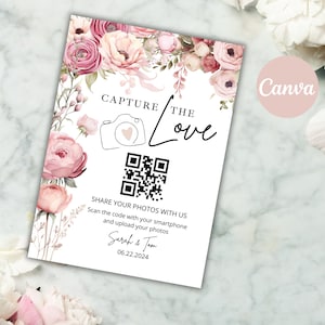 May include: A white card with a pink floral border and a QR code. The text reads "Capture the Love" and includes instructions to scan the code with a smartphone and upload photos. The card also includes the names "Sarah & Tom" and the date "06.22.2024".
