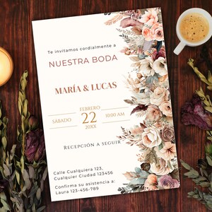 K&ouml;nnte beinhalten: Eine wei&szlig;e Hochzeitseinladung mit einem floralen Rand. Die Einladung lautet "Te invitamos cordialmente a NUESTRA BODA MARIA & LUCAS FEBRERO 22 20XX 10:00 AM RECEPCI&Oacute;N A SEGUIR Calle Cualquiera 123, Cualquier Ciudad 123456 Confirma su asistencia a: Laura 123-456-789"