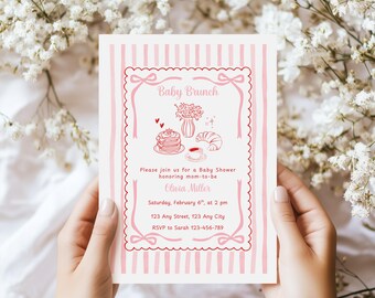 May include: A baby brunch invitation with a pink and white striped background. The invitation features a decorative frame with the words "Baby Brunch" at the top. The invitation includes the text "Please join us for a Baby Shower honoring mom-to-be Olivia Miller."