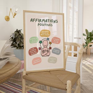 May include: A framed poster with the text "AFFIRMATIONS POSITIVES" in green. The poster features a cartoon figure surrounded by colorful affirmations in French. The poster is displayed on a wooden chair.